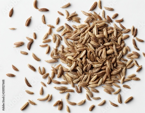 Close-up of Cumin Seeds Scattered on a White Background.