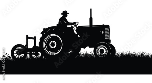 Vintage silhouette of a farmer driving a tractor through a field at sunset