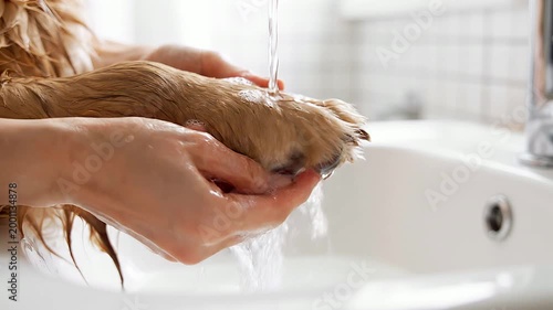 Woman Washing Hands Under Running Water in Bright Bathroom Setting