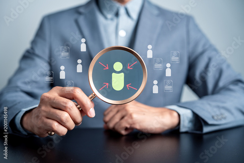 Cuadro en lienzo Businessman holding magnifying glass over candidate icon