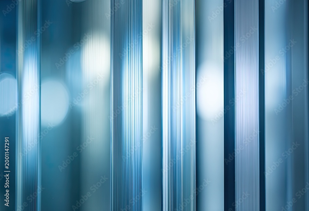 Obraz premium Vertical blue glass panels with soft, blurred lights in the background