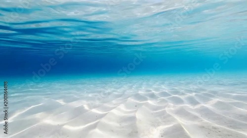 Ultra Clear Tropical Underwater Sand Seabed with Sunlight Caustics and Calm Blue Ocean Surface Background