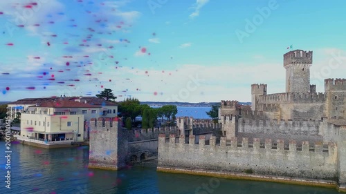 Particles emerging left, sweeping over water while camera panning right, revealing fortress walls