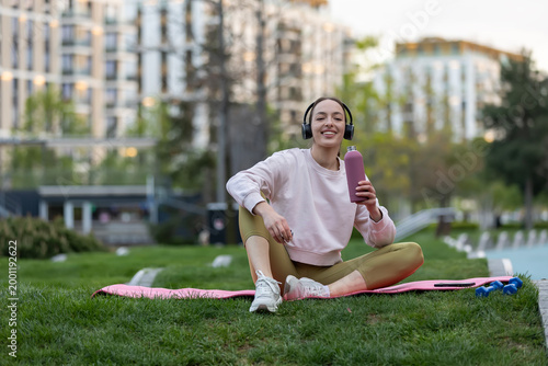 Young woman enjoying break hydrating after fitness workout
