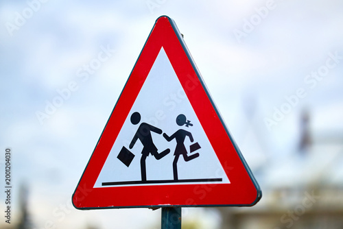 Triangular traffic sign warning of children crossing area