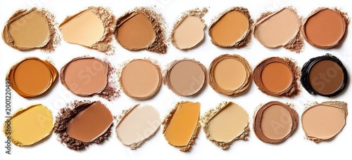 assortment of smeared and pressed foundation and powder swatches in a neat grid of diverse beige, tan and brown shades conveying warm, inclusive beauty