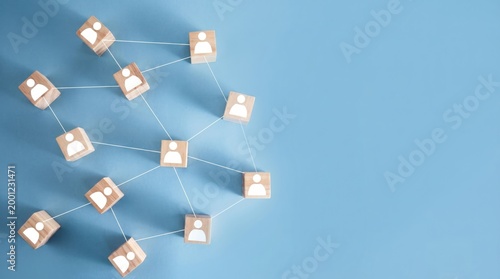 Network of Wooden Blocks with Human Icons on Blue Surface