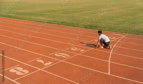 Bild auf Leinwand Runner preps to launch in a race embodying dedication to physical fitness and sp