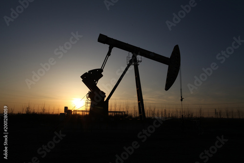 Obraz na płótnie Silhouette of Oil Pump Jack at Oilfield During Sunset
