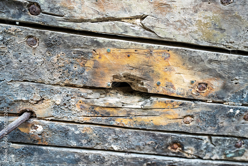 фотографія Close-up of weathered wooden planks with rusted nails and peeling paint, texture