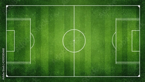 An aerial view showcases a perfectly maintained green soccer field with clearly marked lines.