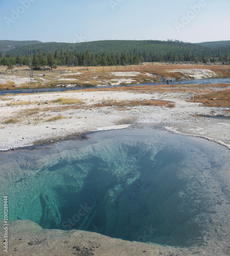 Yellowstone volcanic landscape with Silent Pool geyser with deep and clear turquoise hot spring water