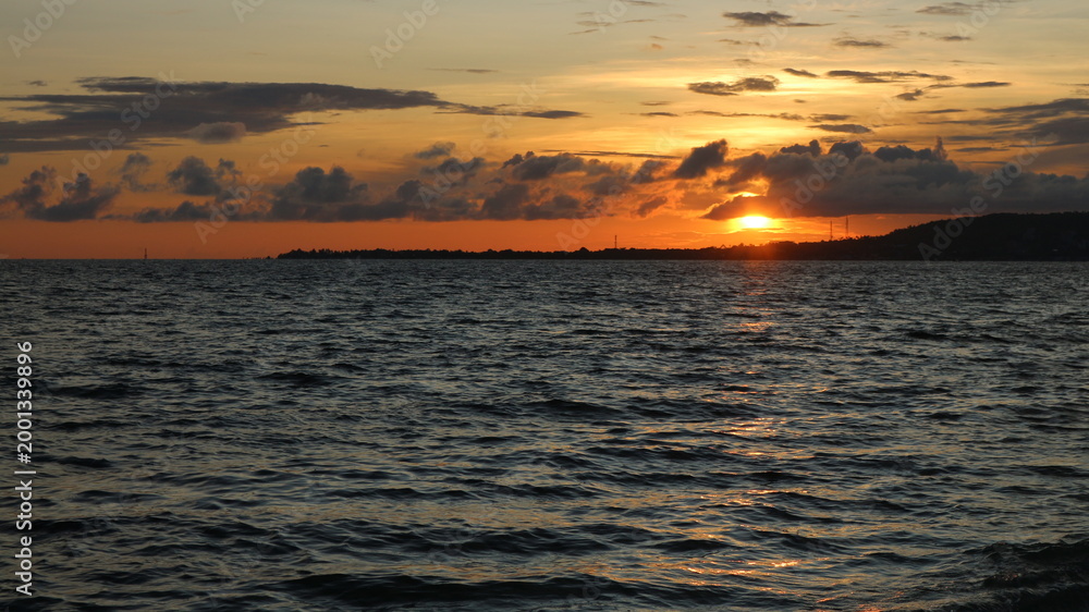 Obraz premium Sun sets over calm ocean waters
