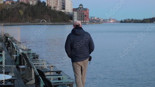 Stockholm, Sweden A man walks at dawn by the Baltic Sea seaside in the Nacka Strand district.  
