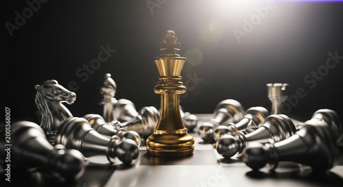 Golden king chess piece standing among fallen silver pieces on a board with dramatic lighting