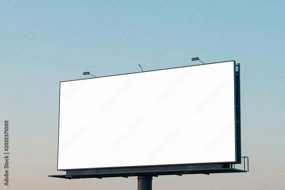 Obraz premium Blank billboard stands tall against a soft blue sky.