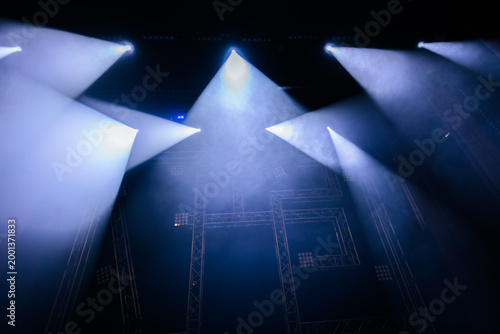 Tableau sur toile Stage lighting beams illuminate a darkened performance area with smoke effects c