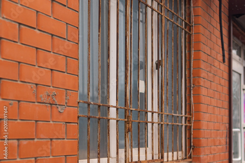 Windows with bars of a typical apartment on the first floor of an old residential building