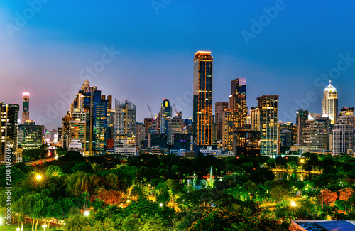 Bangkok city skyline at night with Lumphini Park green space from Dusit Central Park viewpoint, Thailand.