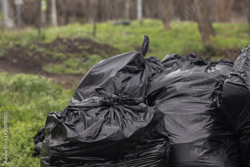 Trash bags on green grass. Close-up image. Ecology problem concept