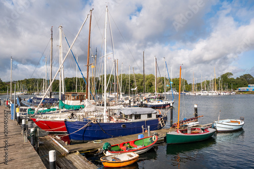 Sailboats and small colorful boats moored at jetty in traditional harbor, Kiel-Friedrichsort, Schleswig-Holstein, Northern Germany