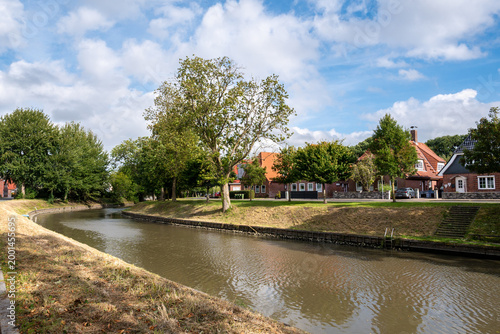 Traditional brick houses along Braake canal in Brunsbuettel, Schleswig-Holstein, Northern Germany