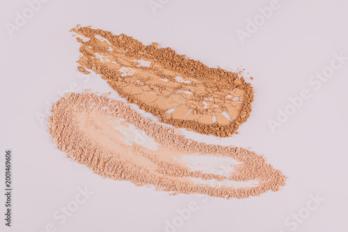 Two strokes of dry powder of various tones on a light surface. Beautiful texture of powder samples. Mockup of decorative cosmetics swatches. Top view.