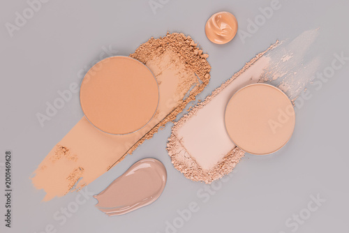 Beautiful samples, swatches, brushstrokes of compact, dry, foundation powder of various tones and textures on light gray background. top view. Layout