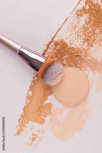 samples, textures of powder of different tones with a makeup brush. Scattered dry powder, round refill. top vertical view. decorative cosmetics