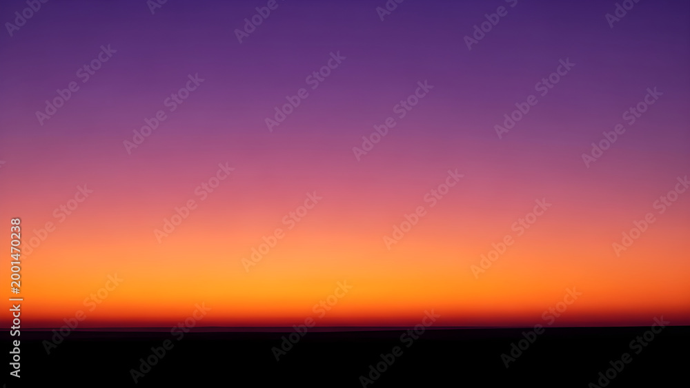 Fototapeta premium Vibrant orange and purple hues fill the sky during a serene sunset