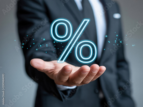 A businessman in a suit holds a glowing percentage sign in his hand