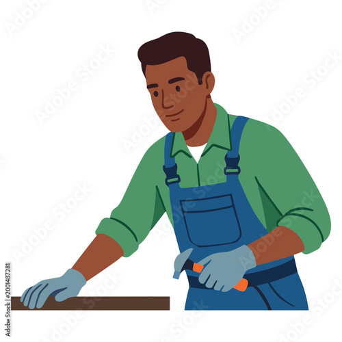 A man in a green shirt and blue overalls works with wood
