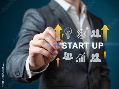 A businessman in a suit draws a start up concept on a screen