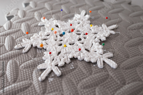 Fotografie Close up of pin-blocked crochet snowflake on technical foam board