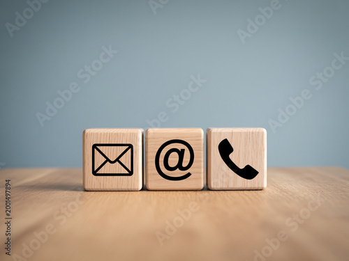 Three wooden blocks with communication symbols on a wooden surface