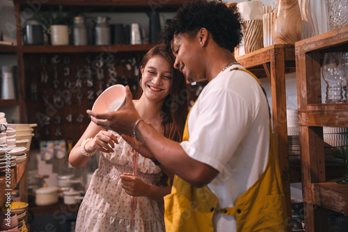 Bilde på lerret Pottery shop young woman young man ceramic bowl handmade bowl smiling face craft