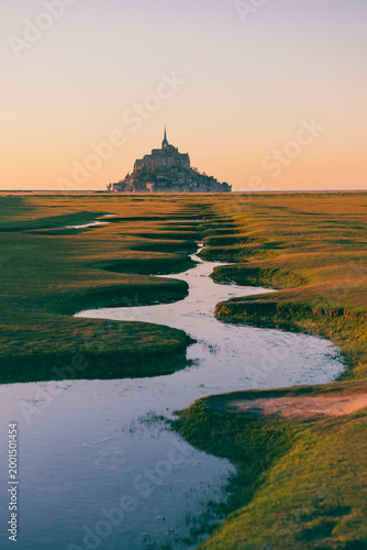 Mont Saint Michel at sunset with winding tidal stream Normandy