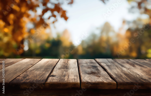 Rustic wooden table with blurred autumnal forest and sky in background