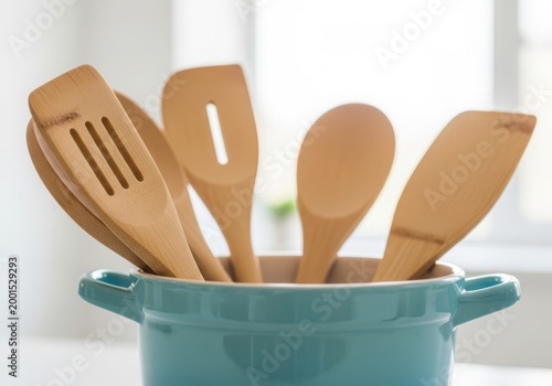 Set of wooden kitchen utensils in a blue pot, closeup