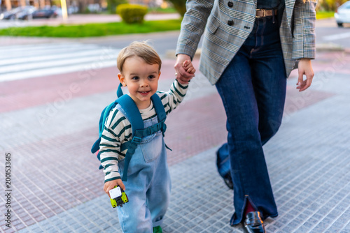 Obraz na płótnie Happy toddler boy walking with parent holding hands