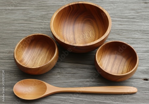 Three wooden bowls and a spoon on a table