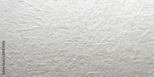 A closeup of white sugar and rice creates a seamless textured background with a rough cement and plaster surface pattern on a blank grey stone material
