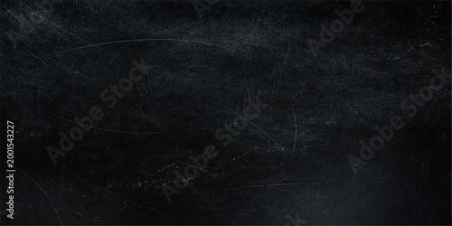 A textured black chalkboard displays various scratches and marks, offering a tactile representation of age and use.