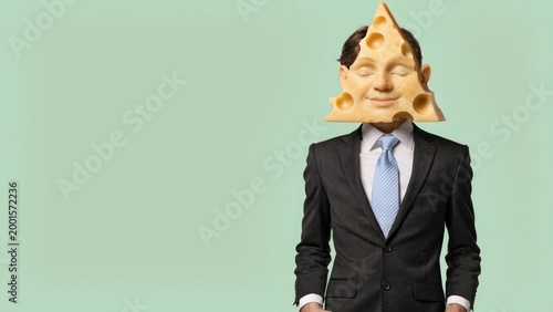 Man in suit with a slice of cheese for a head, embodying a cheesy personality or idea.