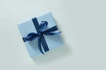 Blue gift box with ribbon on light background