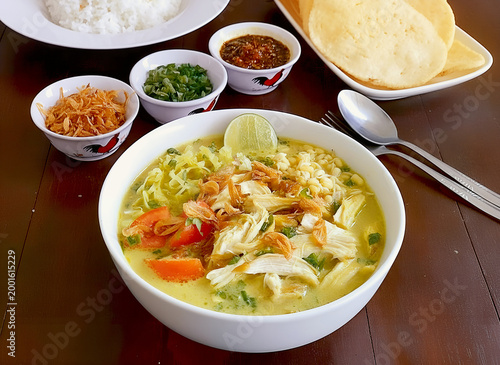 Indonesian Chicken Soup Soto Ayam with Fresh Toppings and Side Dishes. Traditional Indonesian Soto Ayam with Shredded Chicken and Vermicelli