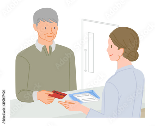 Senior man paying medical bill with credit card at hospital reception