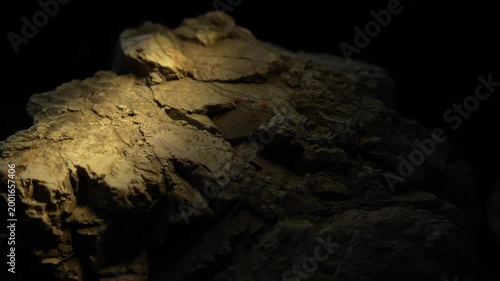 Light beam moving right to left across layered rock surface cinematic texture