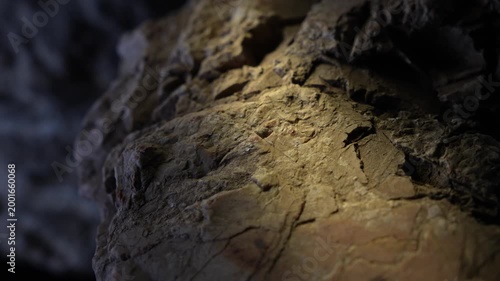 Warm spotlight on broken rock edges with cinematic texture detail