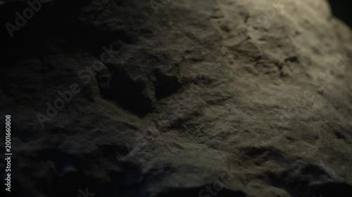 Cinematic camera move over dark rock texture with dramatic light